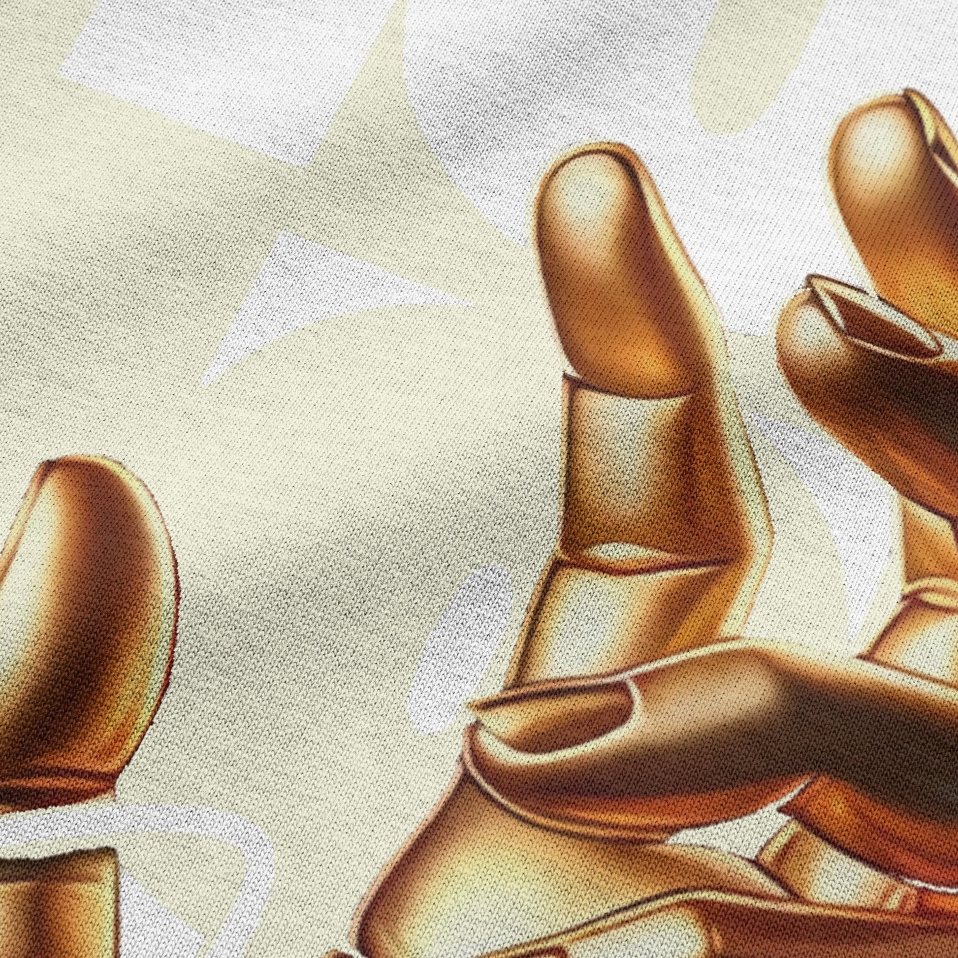 Close-up view of golden hand on beige oversized t-shirt by BLAACK