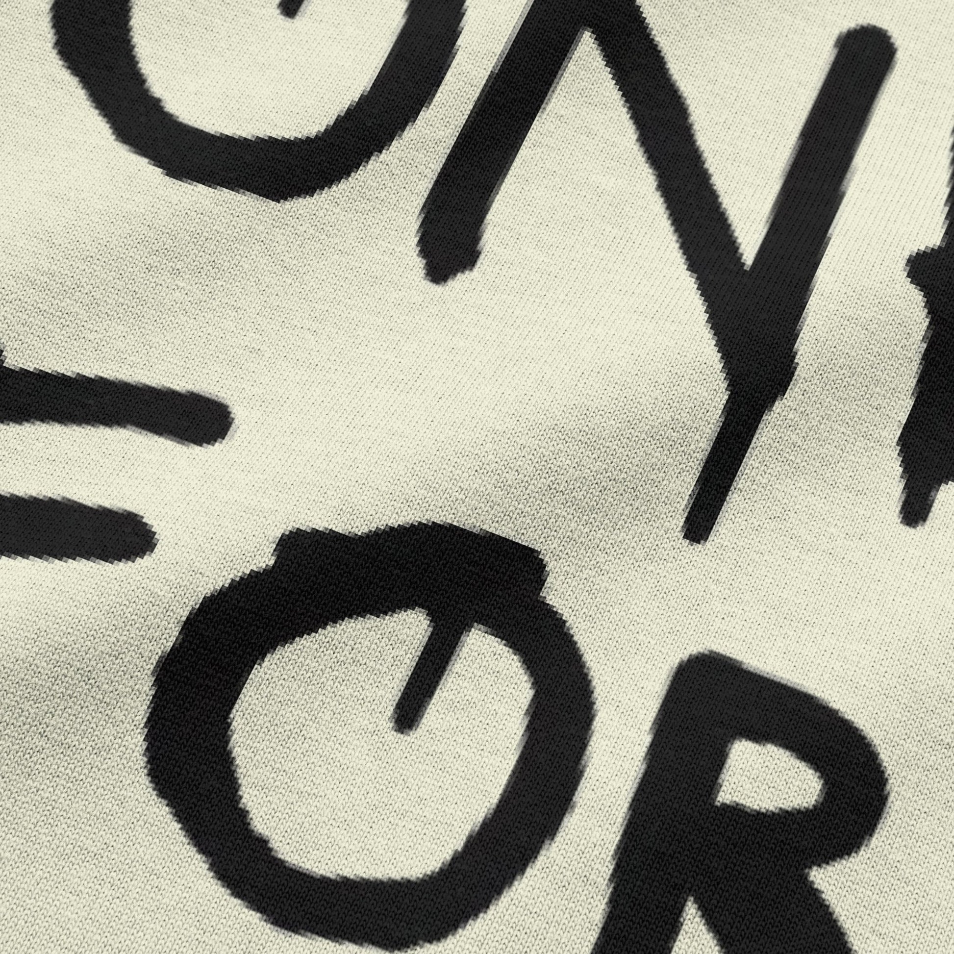 Close-up view of NEED MONEY FOR BMW typography on beige oversized t-shirt by BLAACK